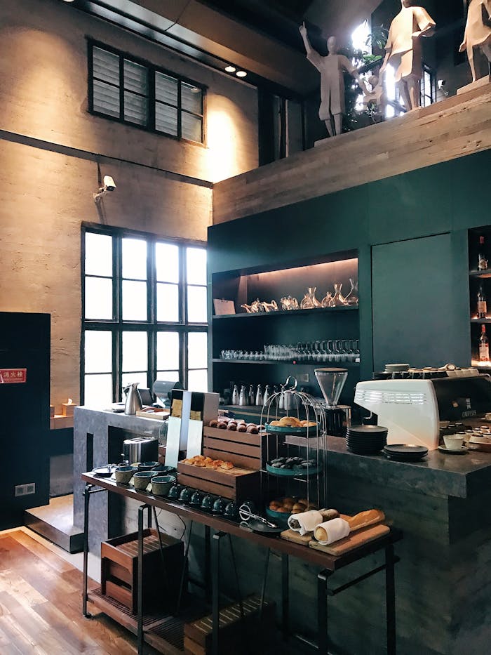 Trendy café interior featuring a modern barista counter with pastries and coffee essentials.
